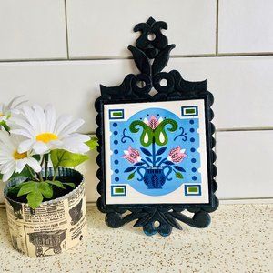Vintage cast iron trivet with blue floral folk art